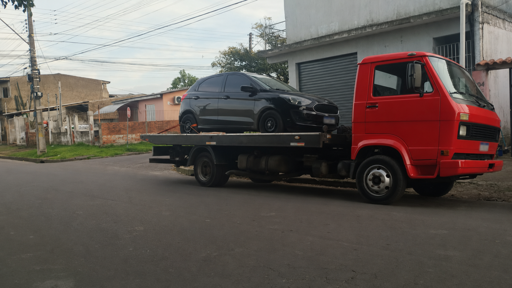 Caminhão guincho vermelho da Foca transportando Ford Ka preto em Porto Alegre